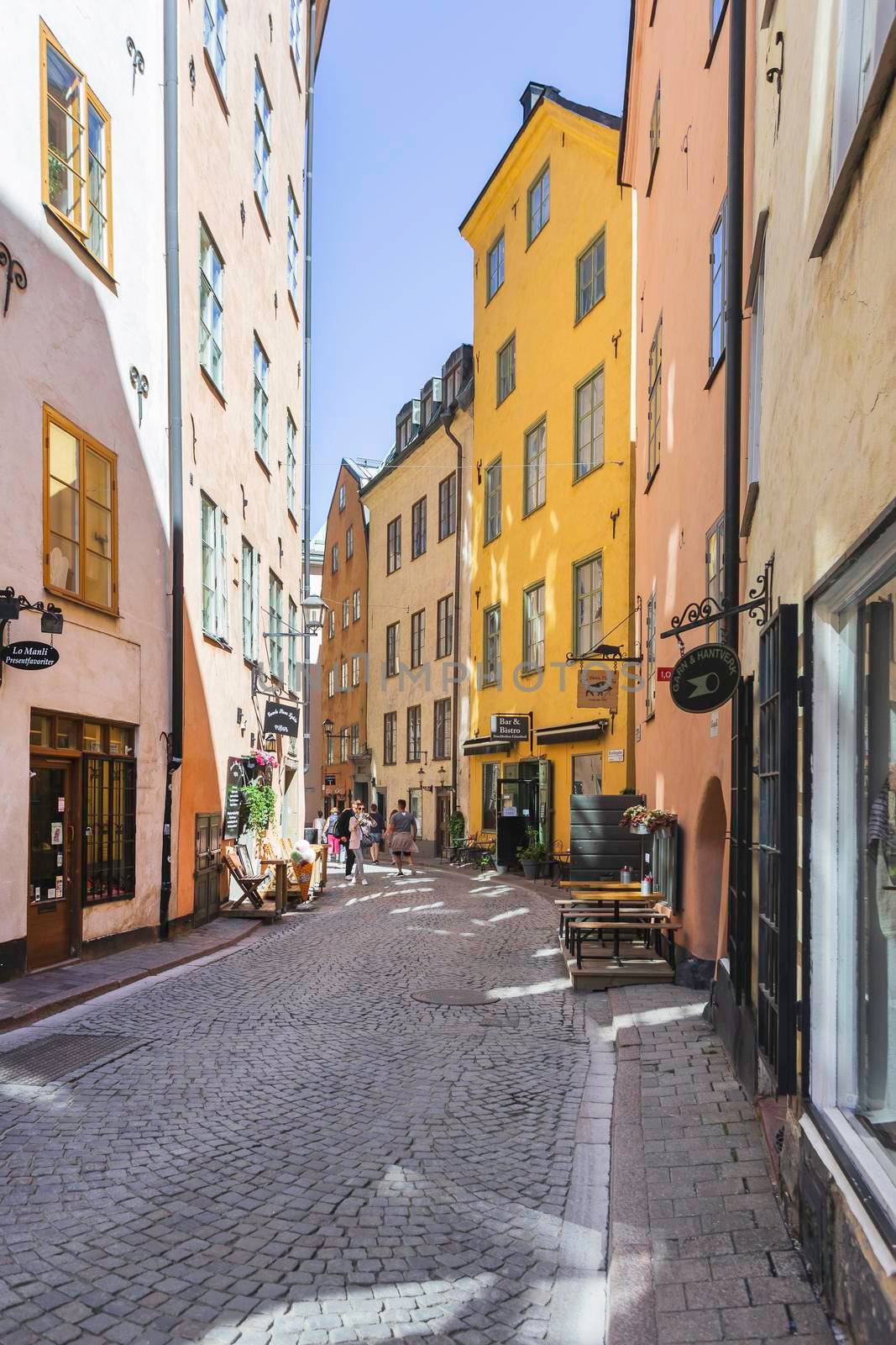 STOCKHOLM, SWEDEN - July 06, 2017. Tourists walk on narrow streets in historic part of town. Old fashioned buildings in Gamla stan. by aksenovko