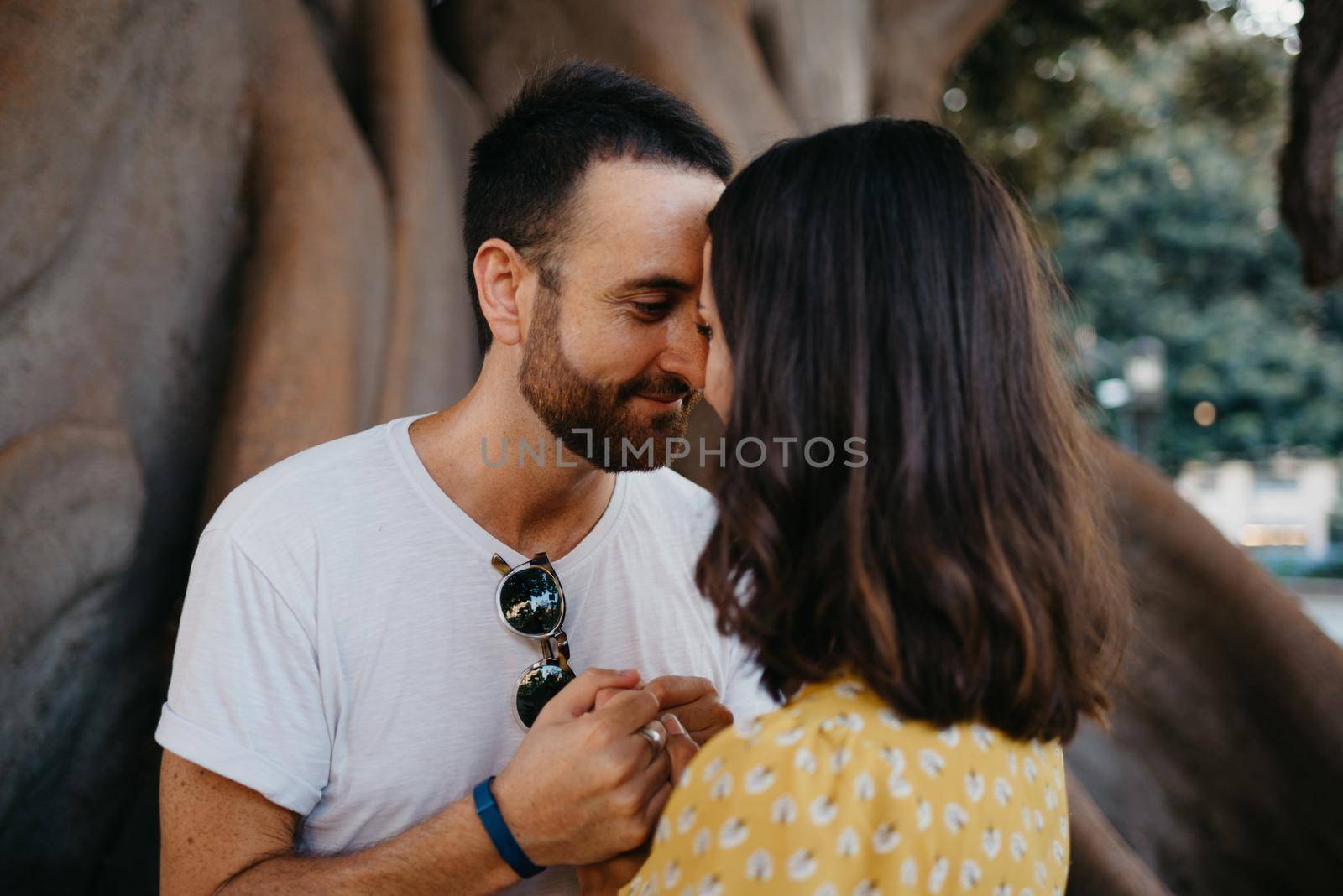 Girl and a boyfriend are holding hands under an old Valencian Ficus Macrophylla by RomanJRoyce