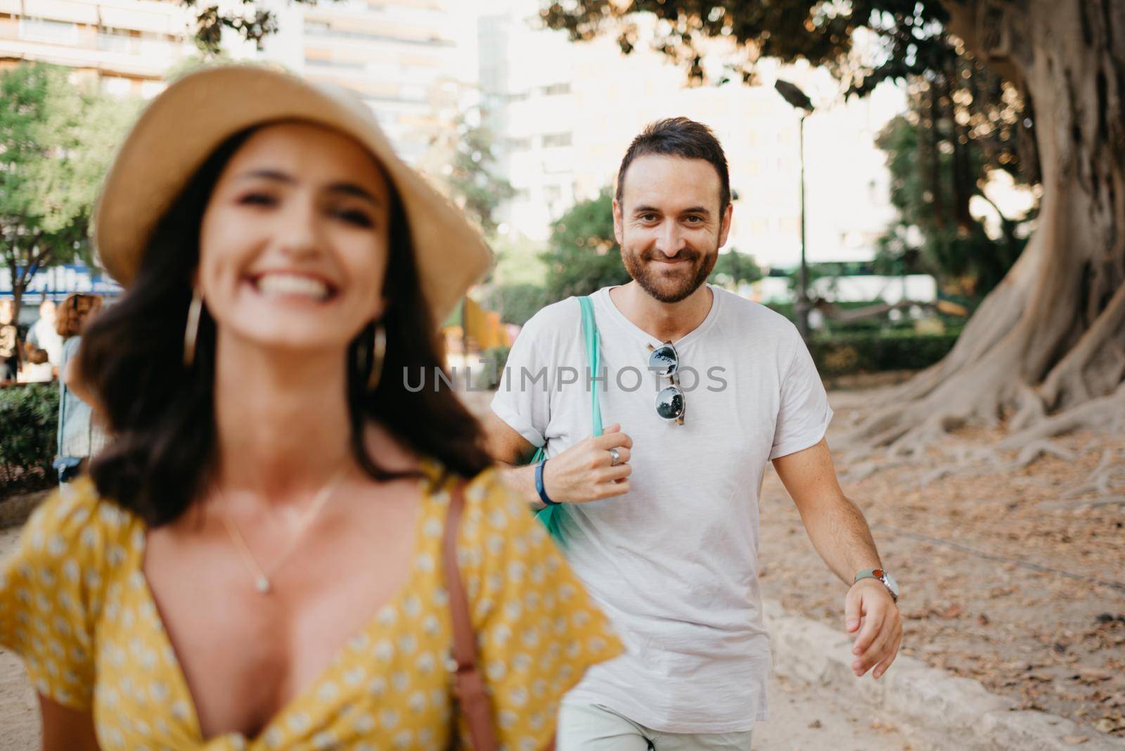 Woman with her boyfriend go to an old Valencian Ficus Macrophylla tree in Spain by RomanJRoyce