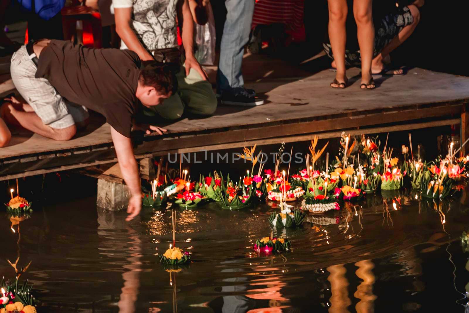 PHUKET, THAILAND - November 28, 2012. Local people and tourists celebrate Loy Krathong by releasing ritual vessel or lamp to float in sea. Traditional Thai festival. by aksenovko