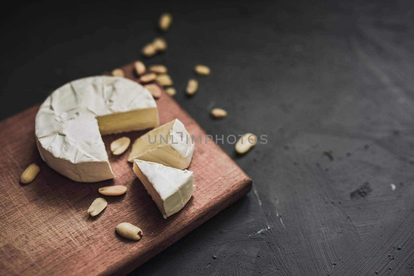 cheese camembert with mold and nuts on wooden board by AndriiDrachuk