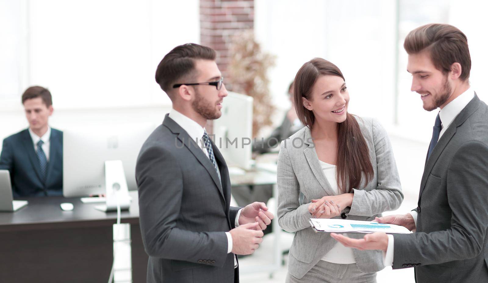 Portrait of confident employees looking at document at meeting