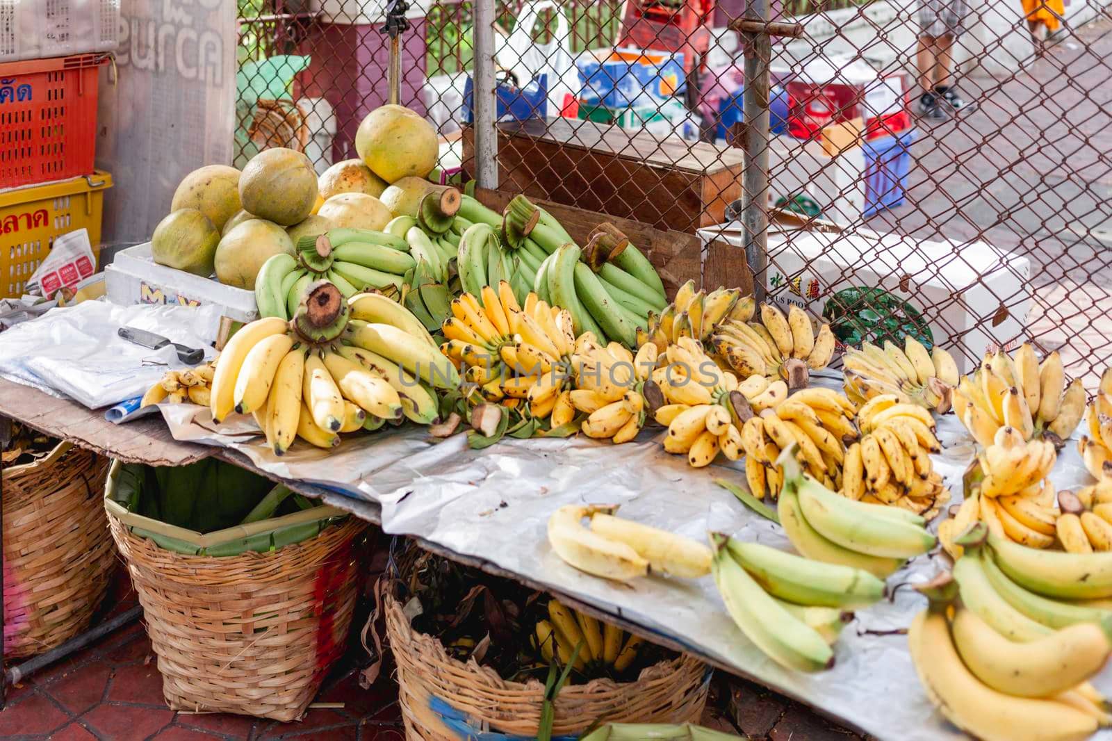 BANGKOK, THAILAND - October 23, 2012. Bananas and pomelos on stall at marketplace. Traditional local fruits on street market. by aksenovko