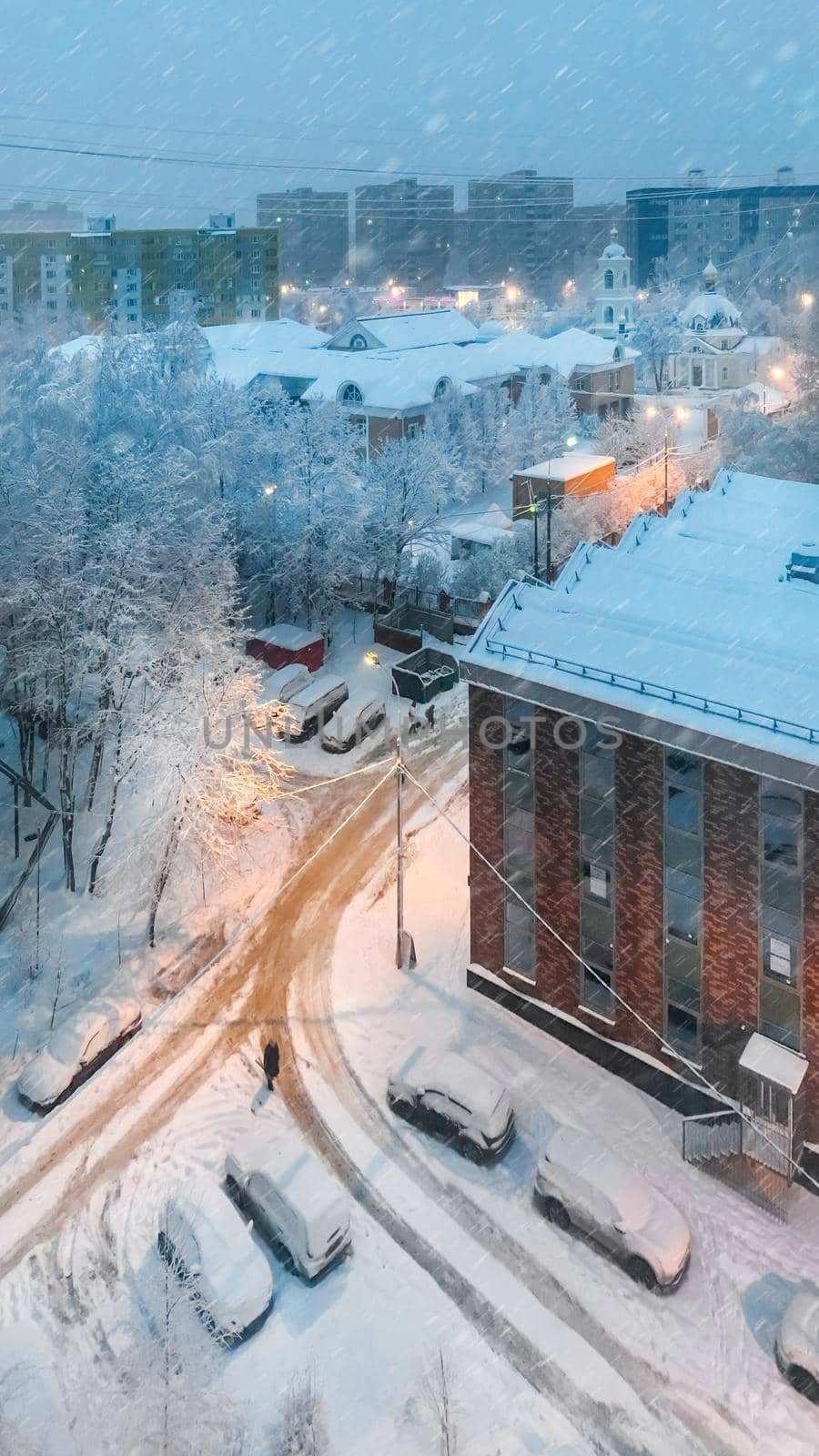 Winter snowy evening. Upper view on Grebnevskaya church and apartment buildings in Odintsovo, Russia. by aksenovko
