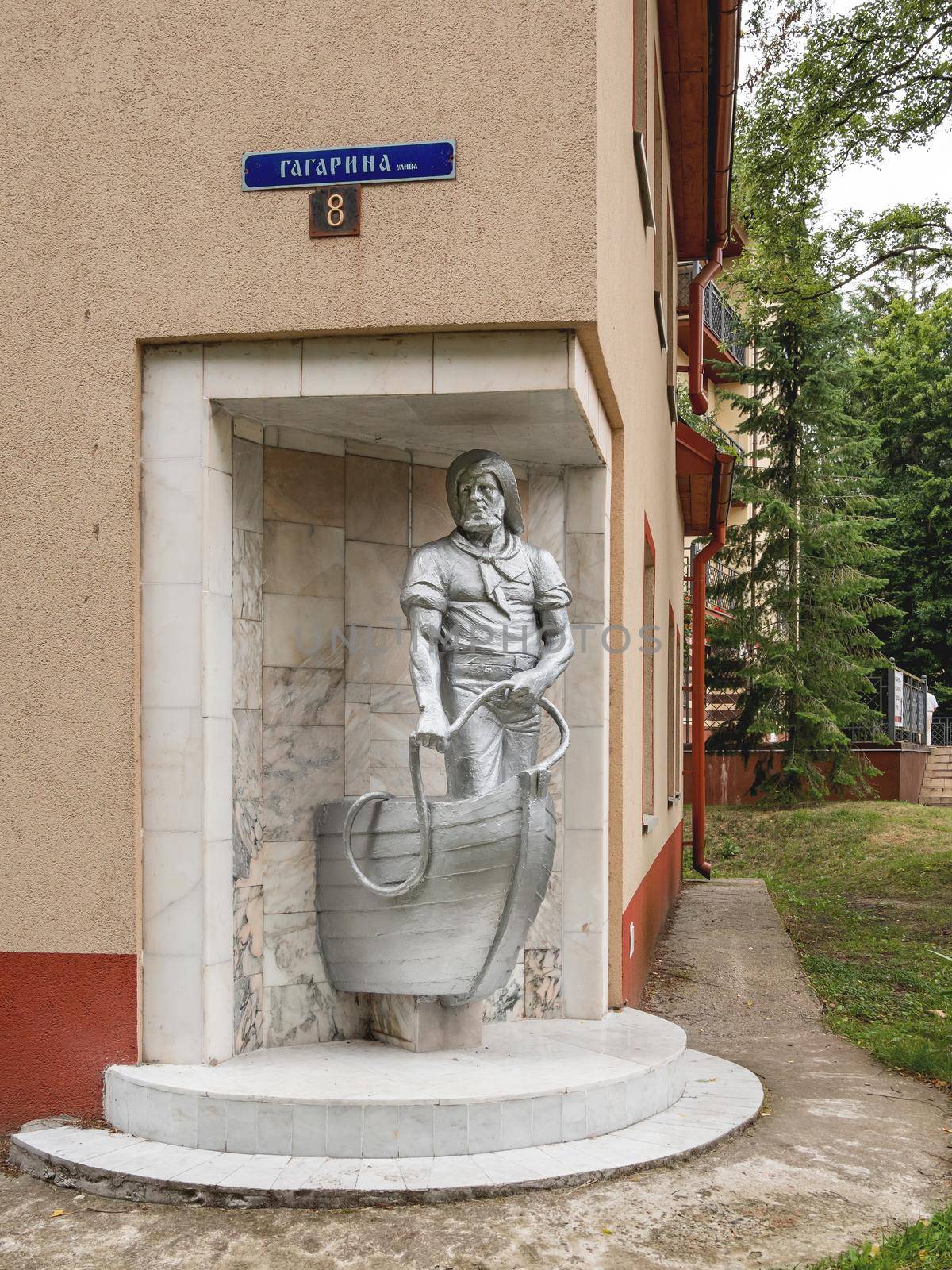 SVETLOGORSK, RUSSIA - July 21, 2019. Old monument dedicated to fisherman built into corner of apartment building.
