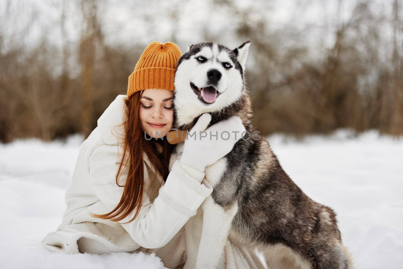 young woman in the snow playing with a dog fun friendship Lifestyle by SHOTPRIME