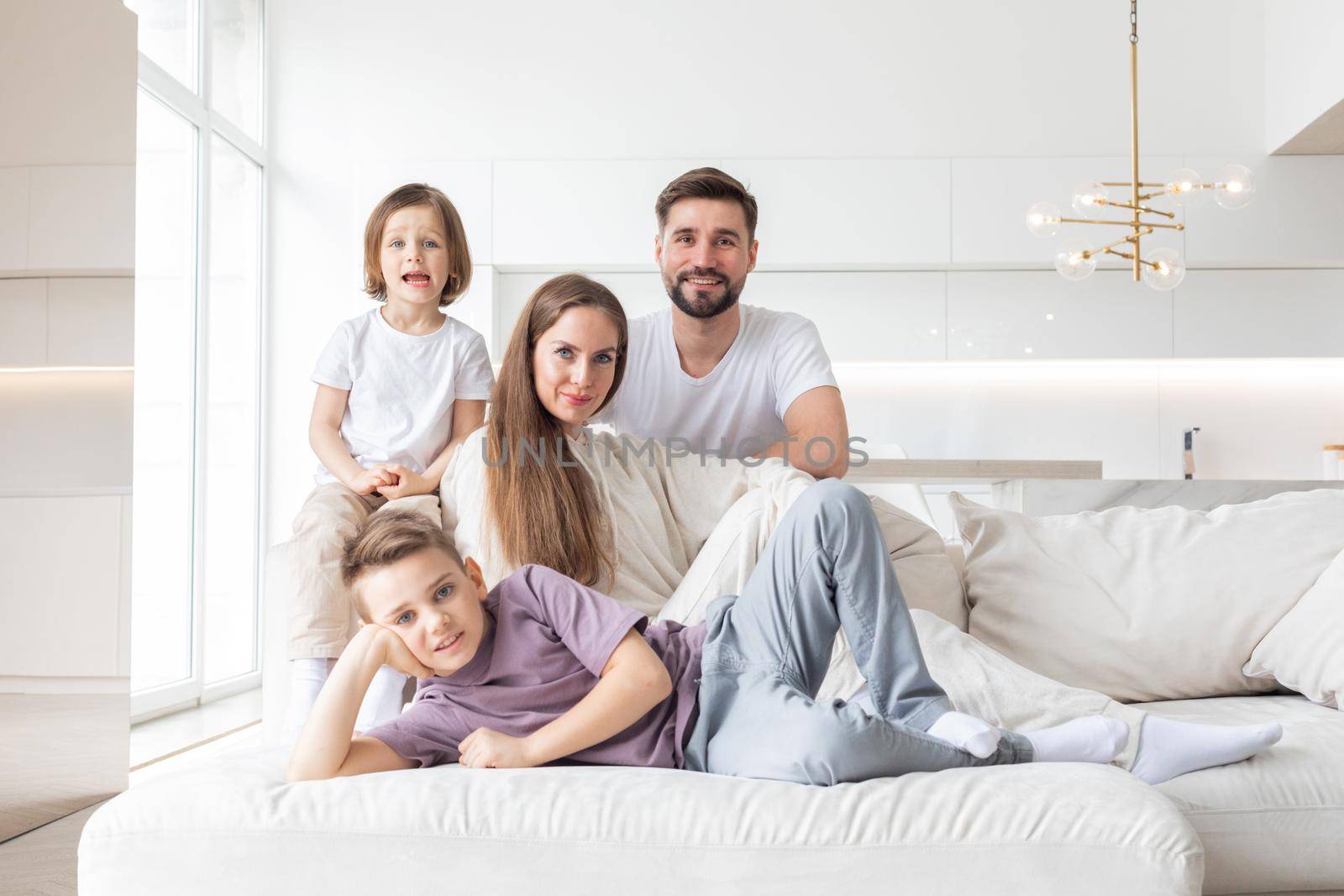 Happy family with children on sofa by ALotOfPeople