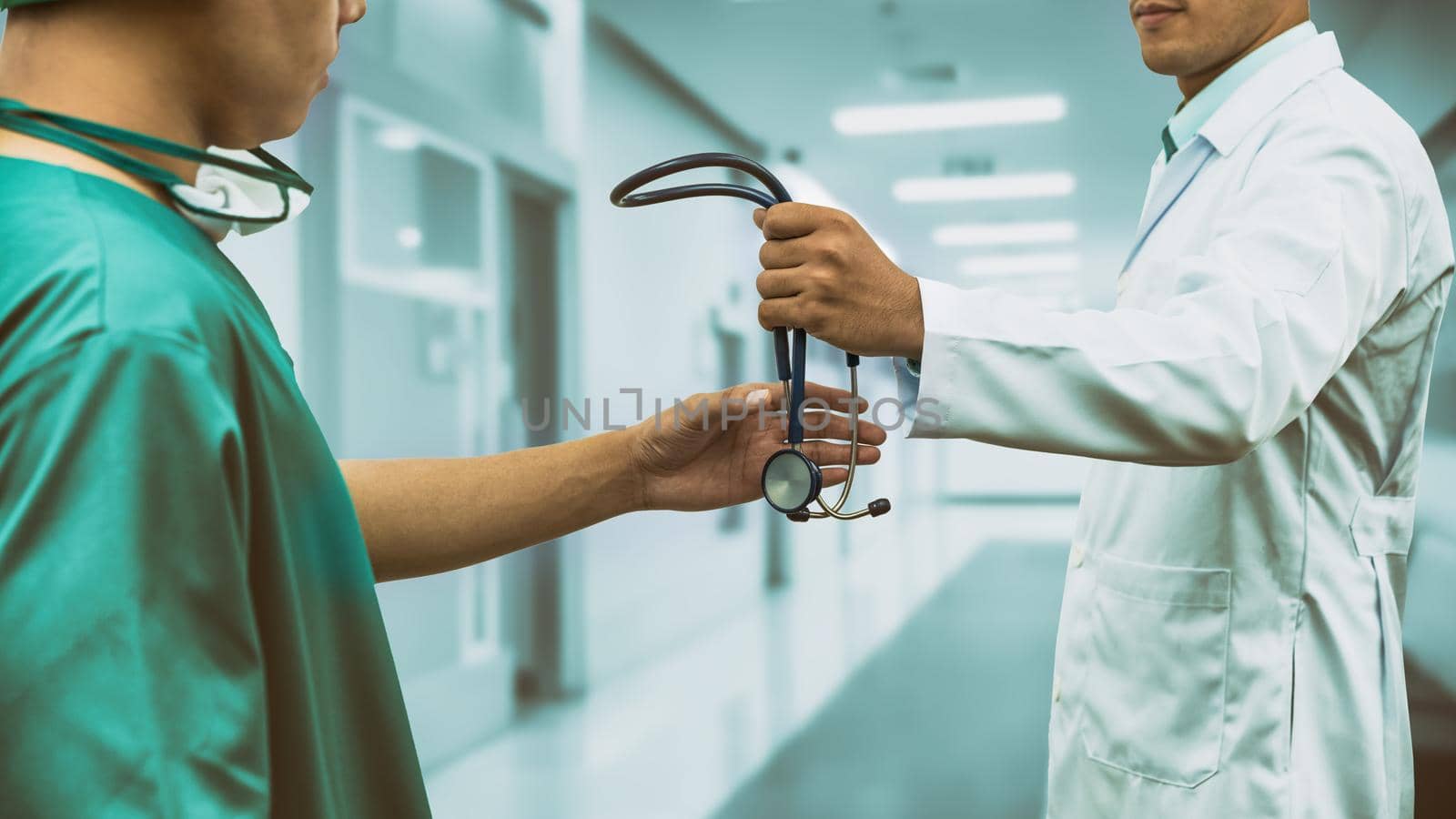 Doctor passing stethoscope to surgeon. Concept of specialist referral patients from general practitioner GP for further medication.