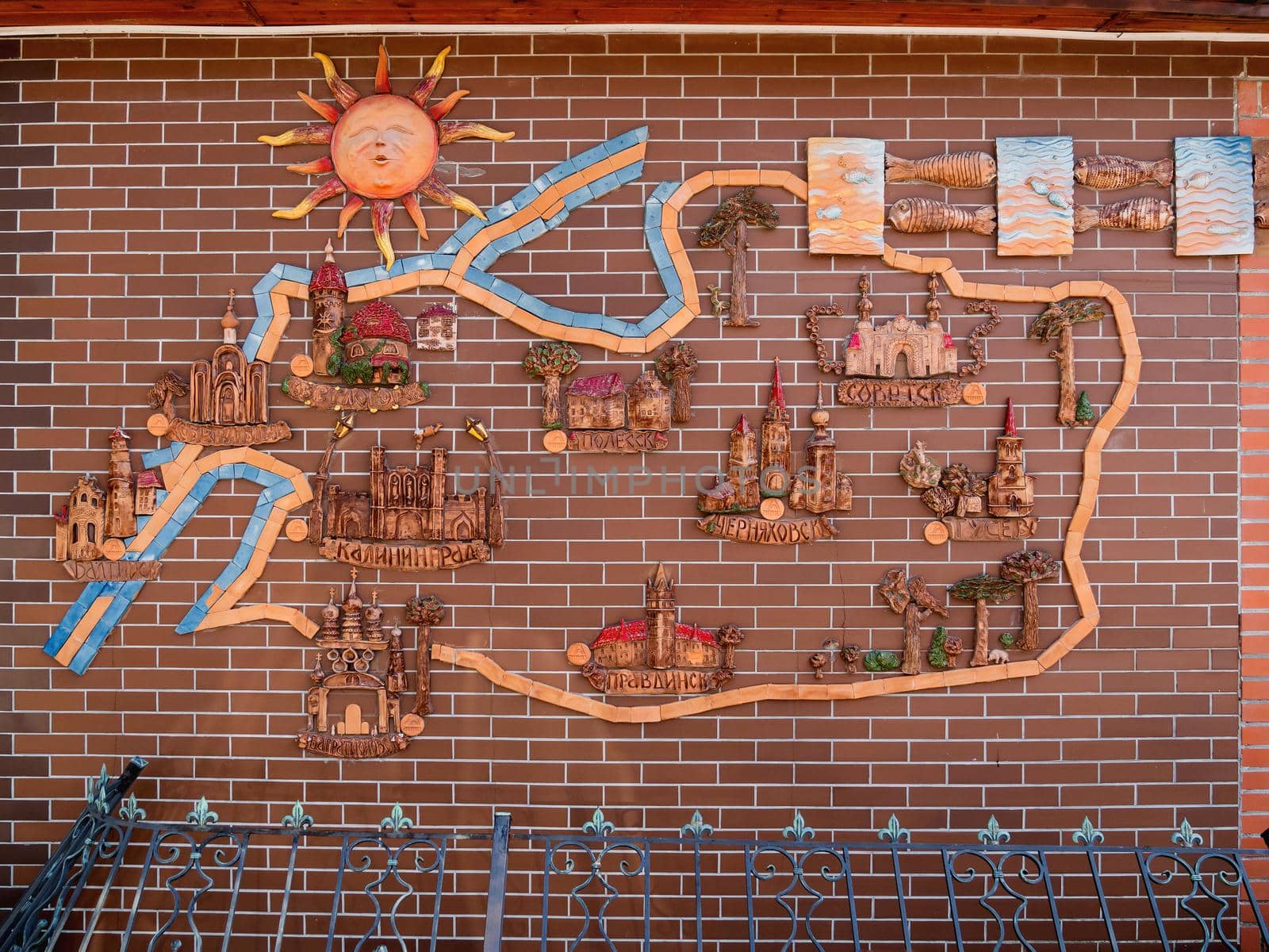 SVETLOGORSK, RUSSIA - July 21, 2019. Hand made decorative clay map of Kaliningradskaya area on red brick building. by aksenovko