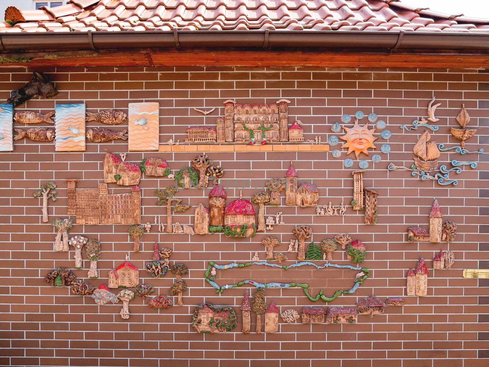 SVETLOGORSK, RUSSIA - July 21, 2019. Hand made decorative clay map of Kaliningradskaya area on red brick building. by aksenovko
