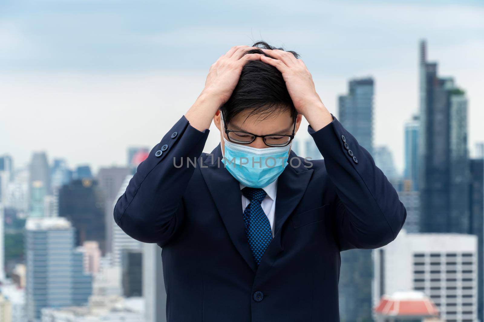 Unhappy lost business man with face mask protect from Coronavirus or Covid-19 suffers economic recession trouble. Concept of unemployment problem crisis caused by pandemic of Coronavirus Covid-19.