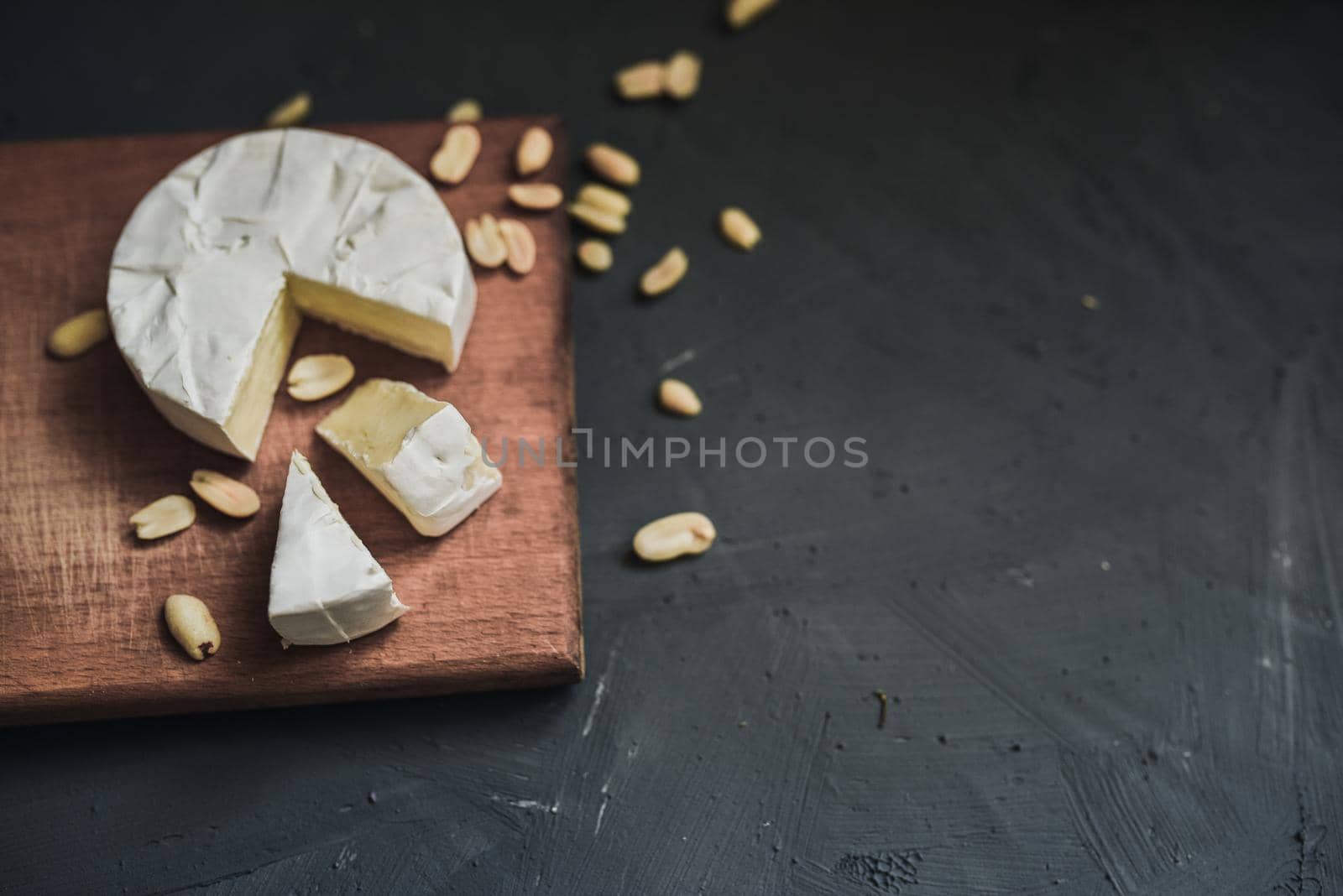 cheese camembert with mold and nuts on the wooden cutting board