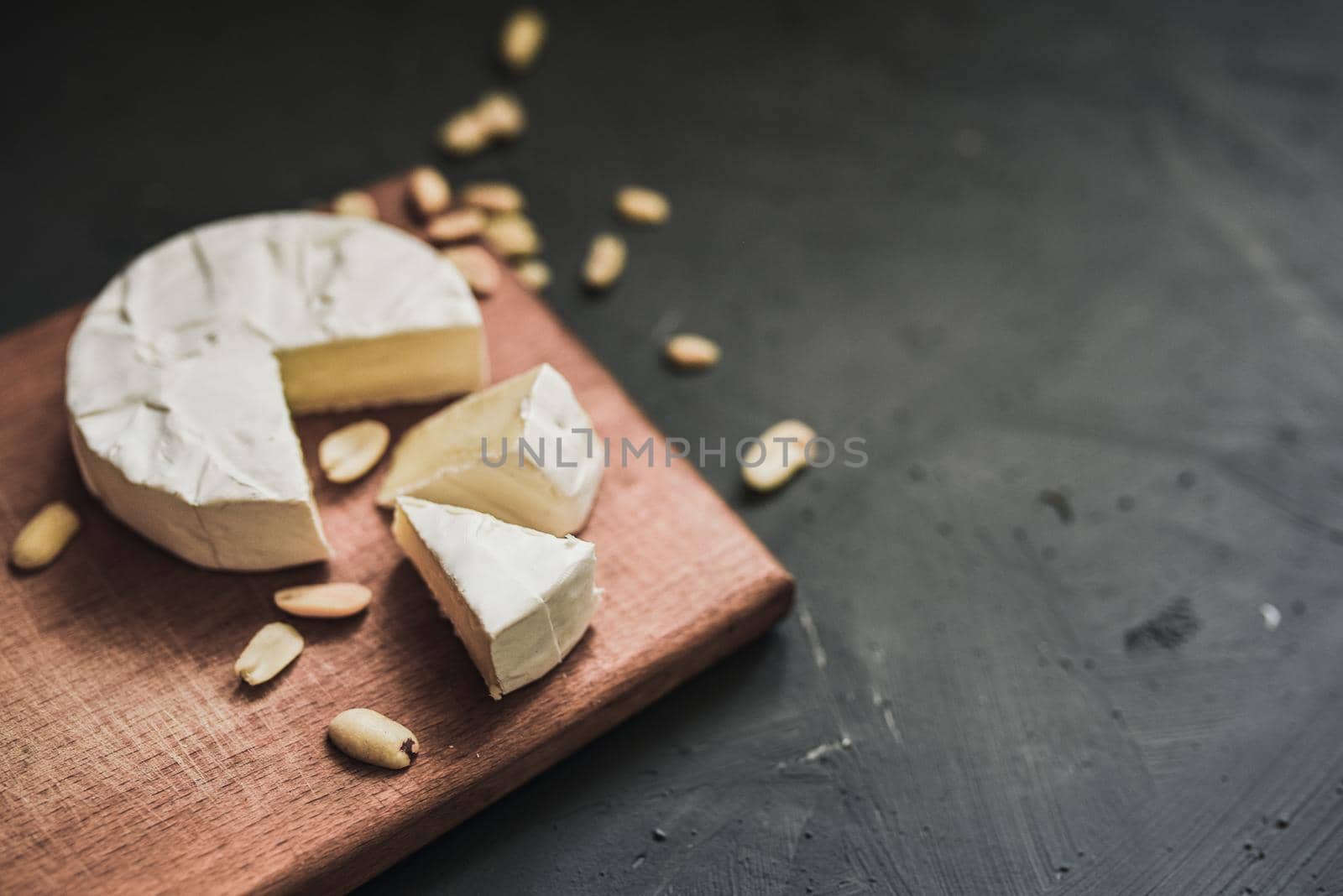 cheese camembert with mold and nuts on the wooden cutting board