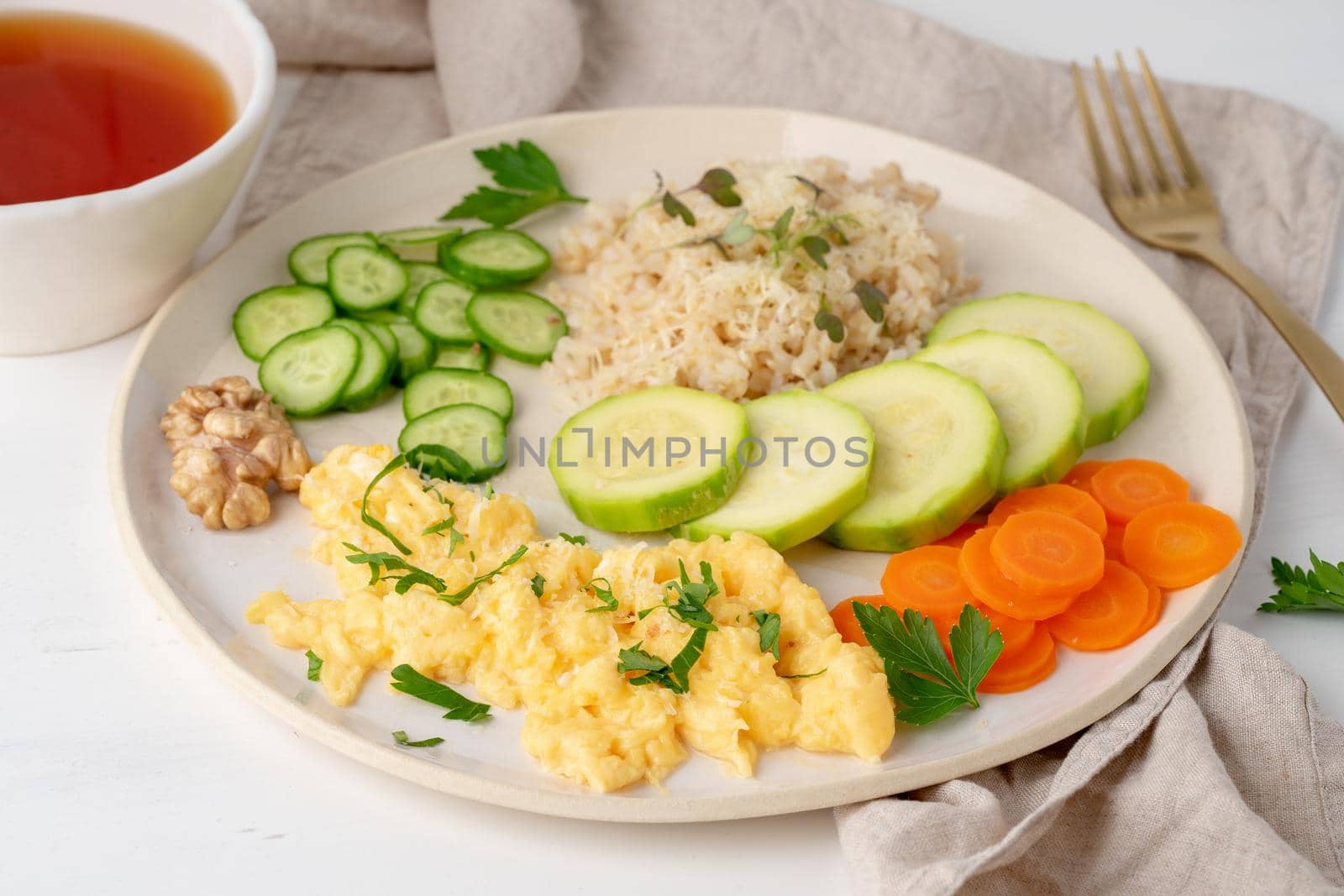 clean eating brown rice with zucchini and scramble with carrot and parsley, top view closeup