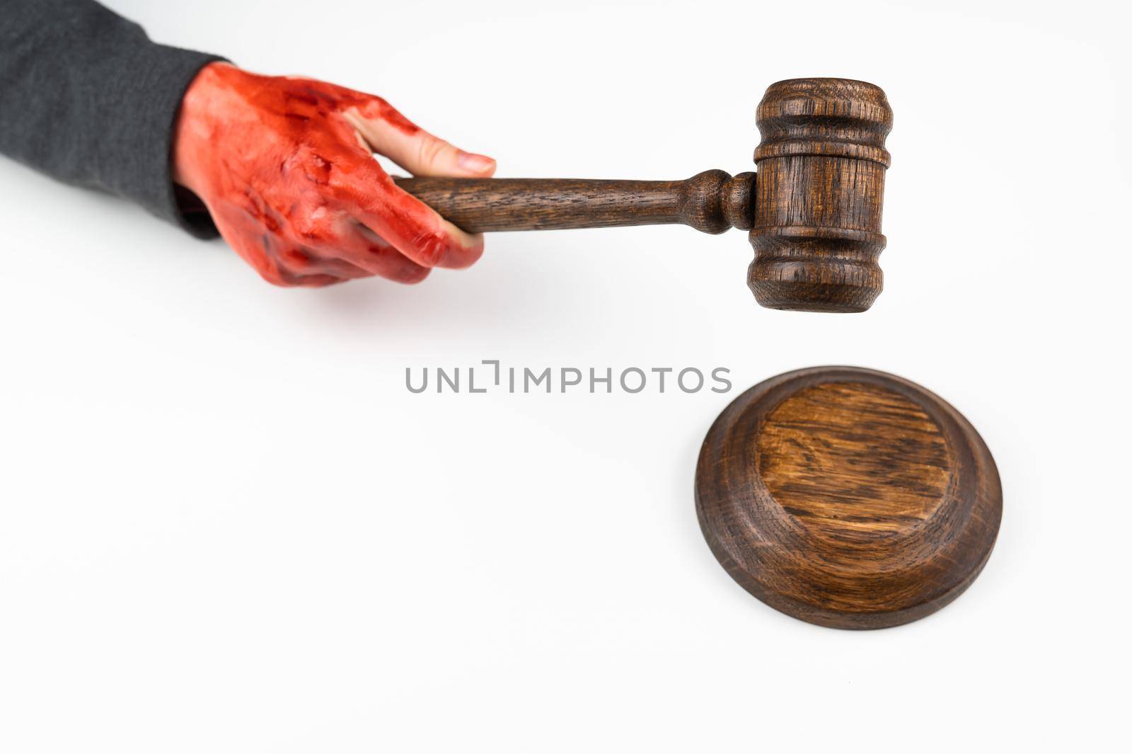 Female judge with bloody hands beats the gavel on a white background