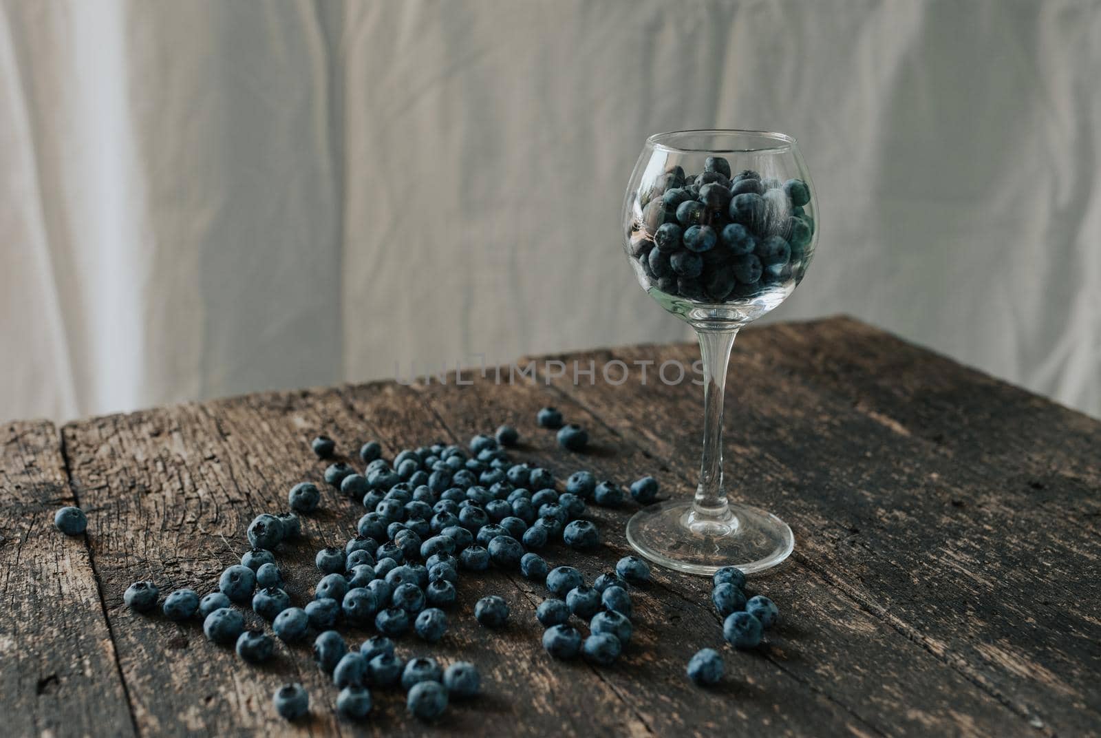 blueberries filled in a transparent glass and scattered by AndriiDrachuk