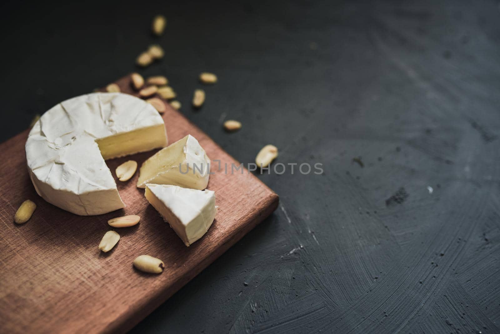 cheese camembert with mold and nuts on the wooden cutting board