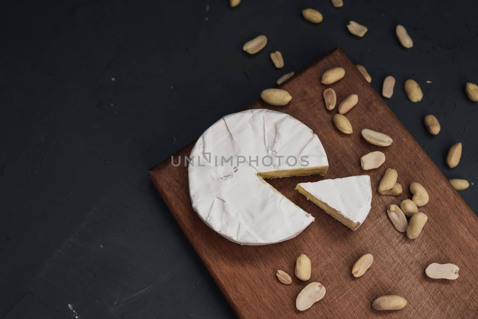 cheese camembert with mold and nuts on wooden board by AndriiDrachuk
