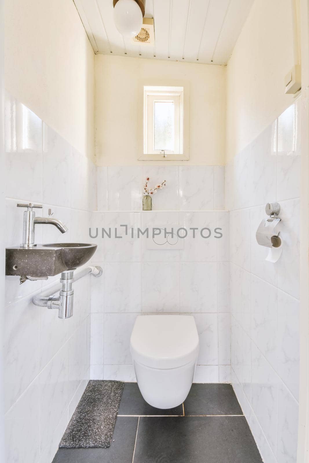 A small bathroom in black and white style with a hinged toilet and sink in a modern apartment