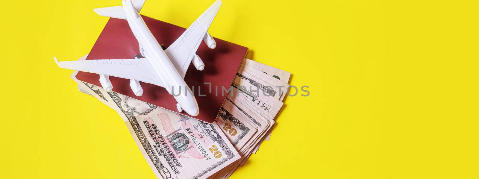 Travel preparation concept of airplane, money, passport, on yellow background. Selective focus.holidays