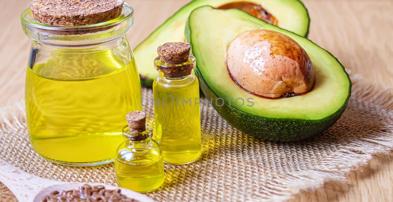 Avocado and avocado oil on wooden background. Selective focus by mila1784