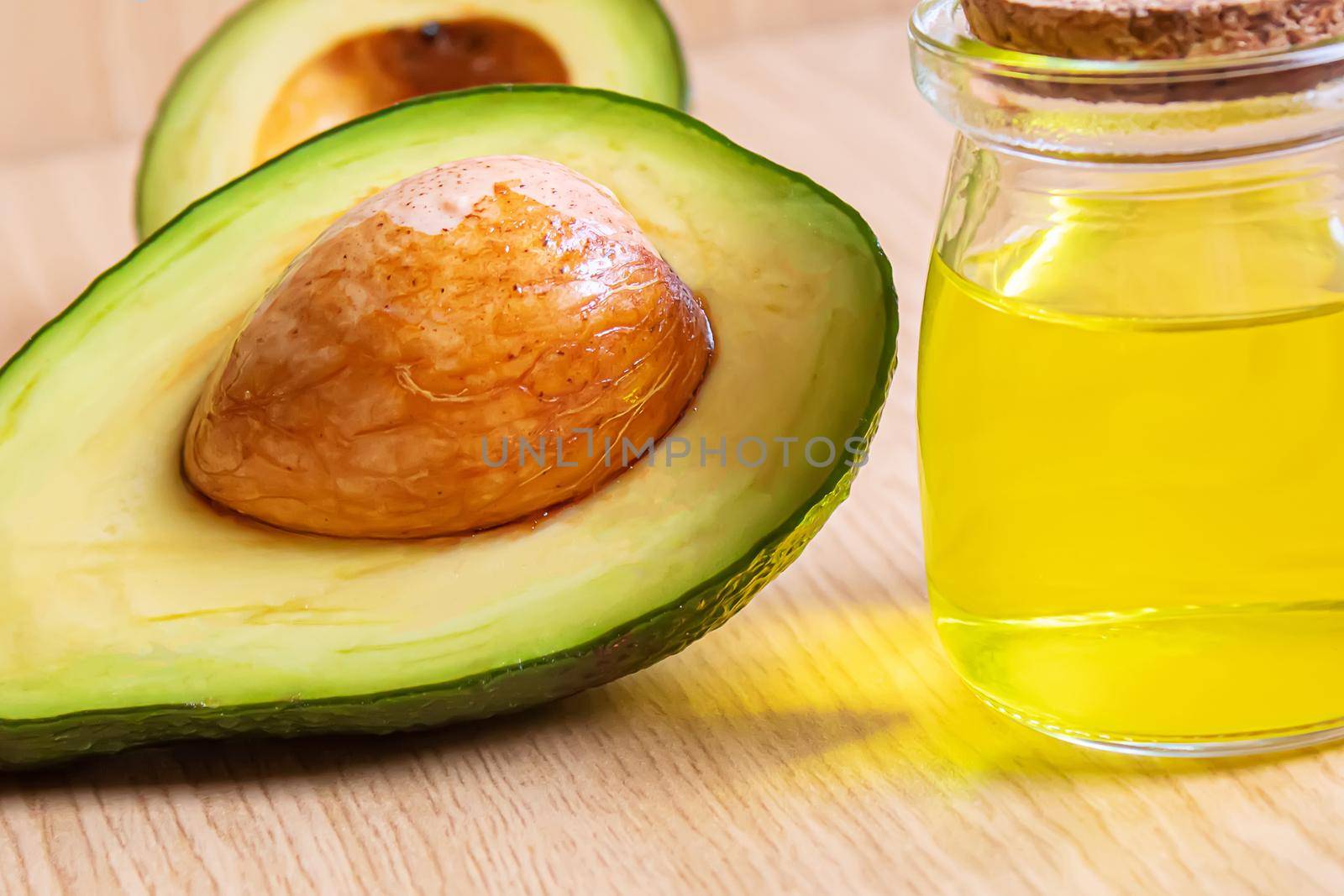 Avocado and avocado oil on wooden background. Selective focus by mila1784