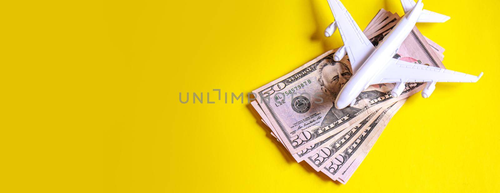 Travel preparation concept of airplane, money, passport, on yellow background. Selective focus by mila1784
