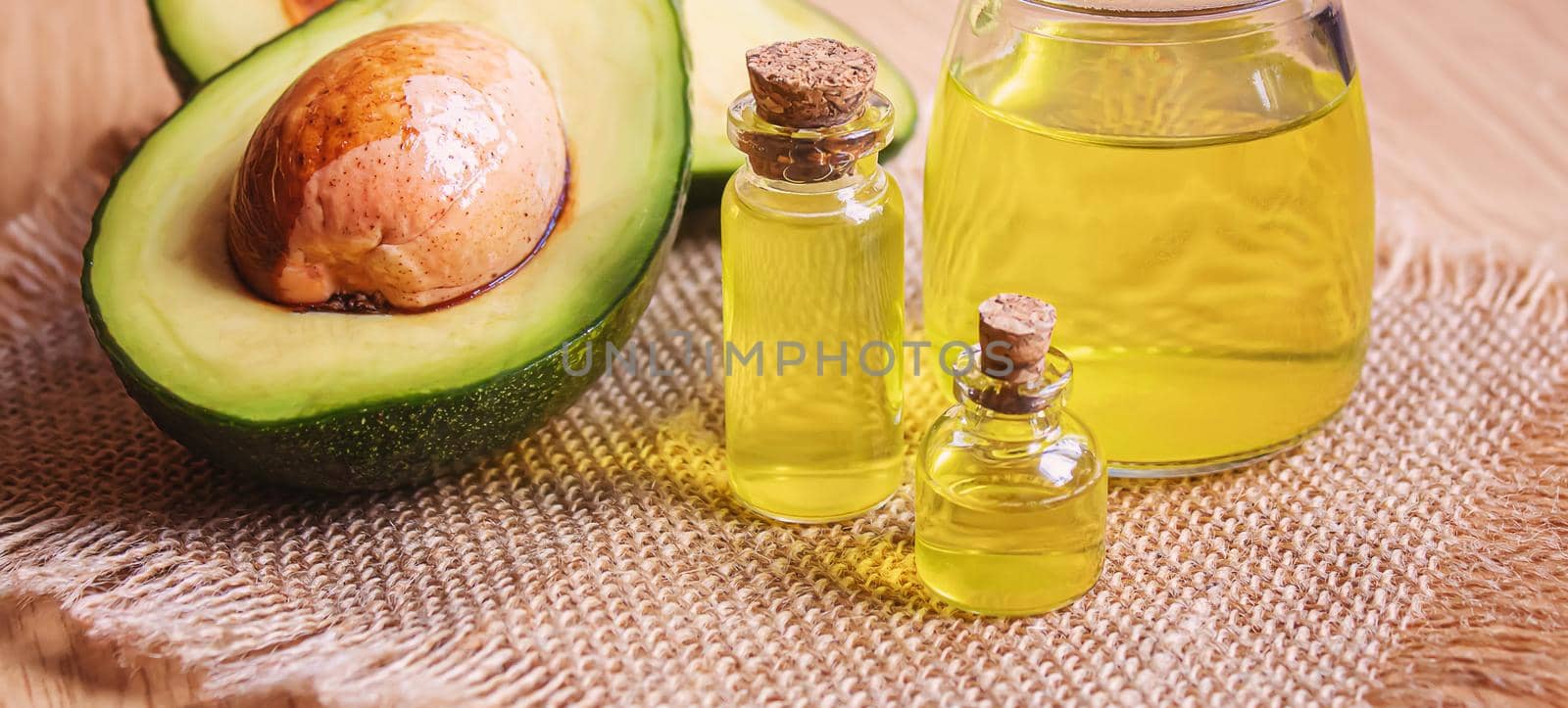 Avocado and avocado oil on wooden background. Selective focus.food