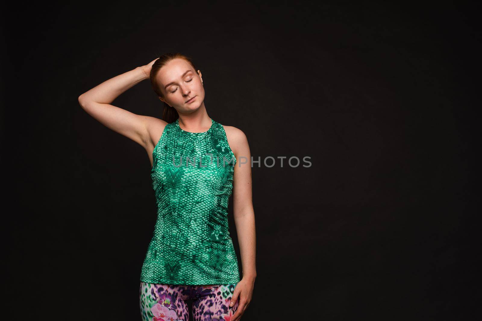 Strong red haired woman in sport uniform posing by StudioLucky