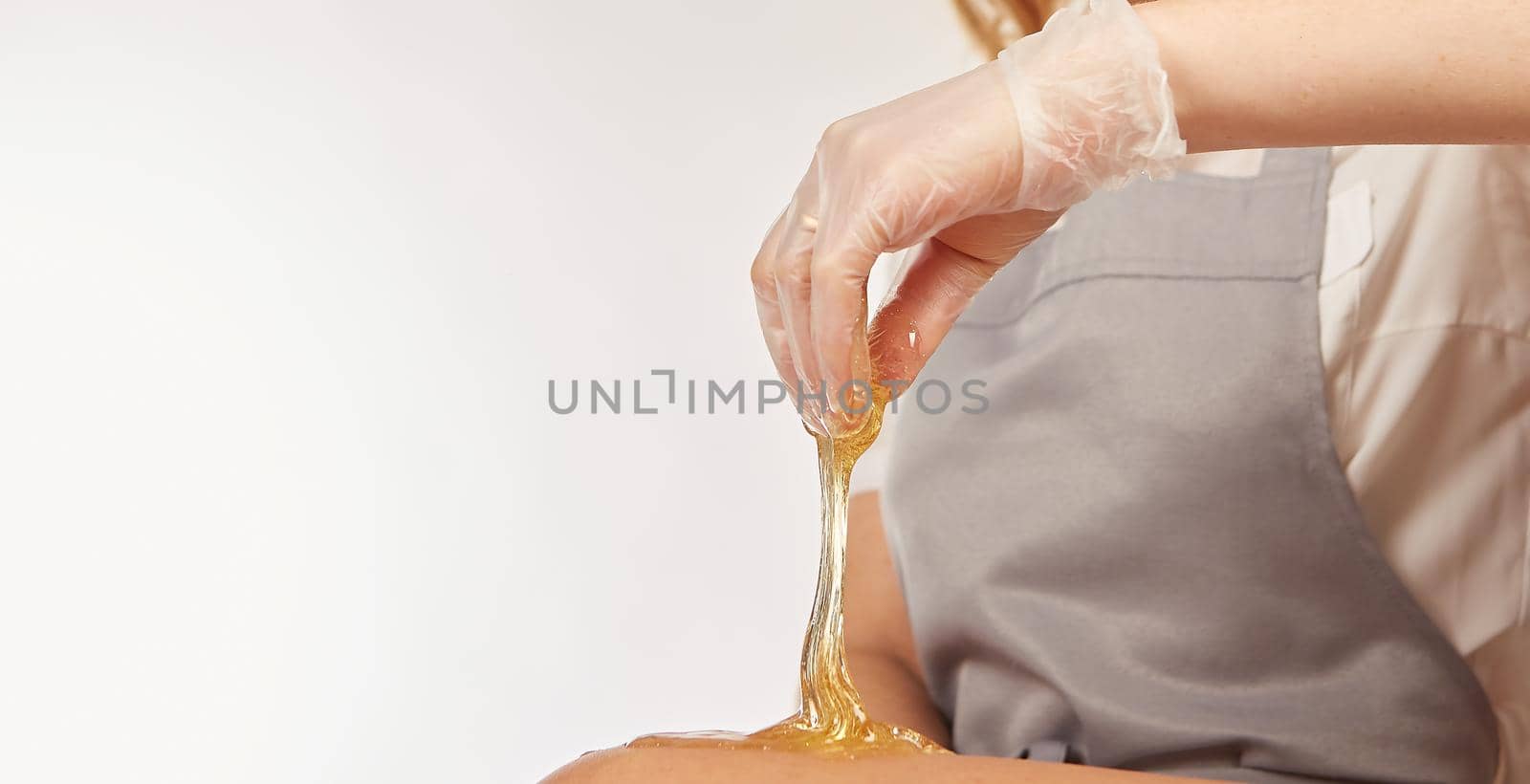 Sugar paste for light depilation. Depilation with sugar paste in the salon on a white background.