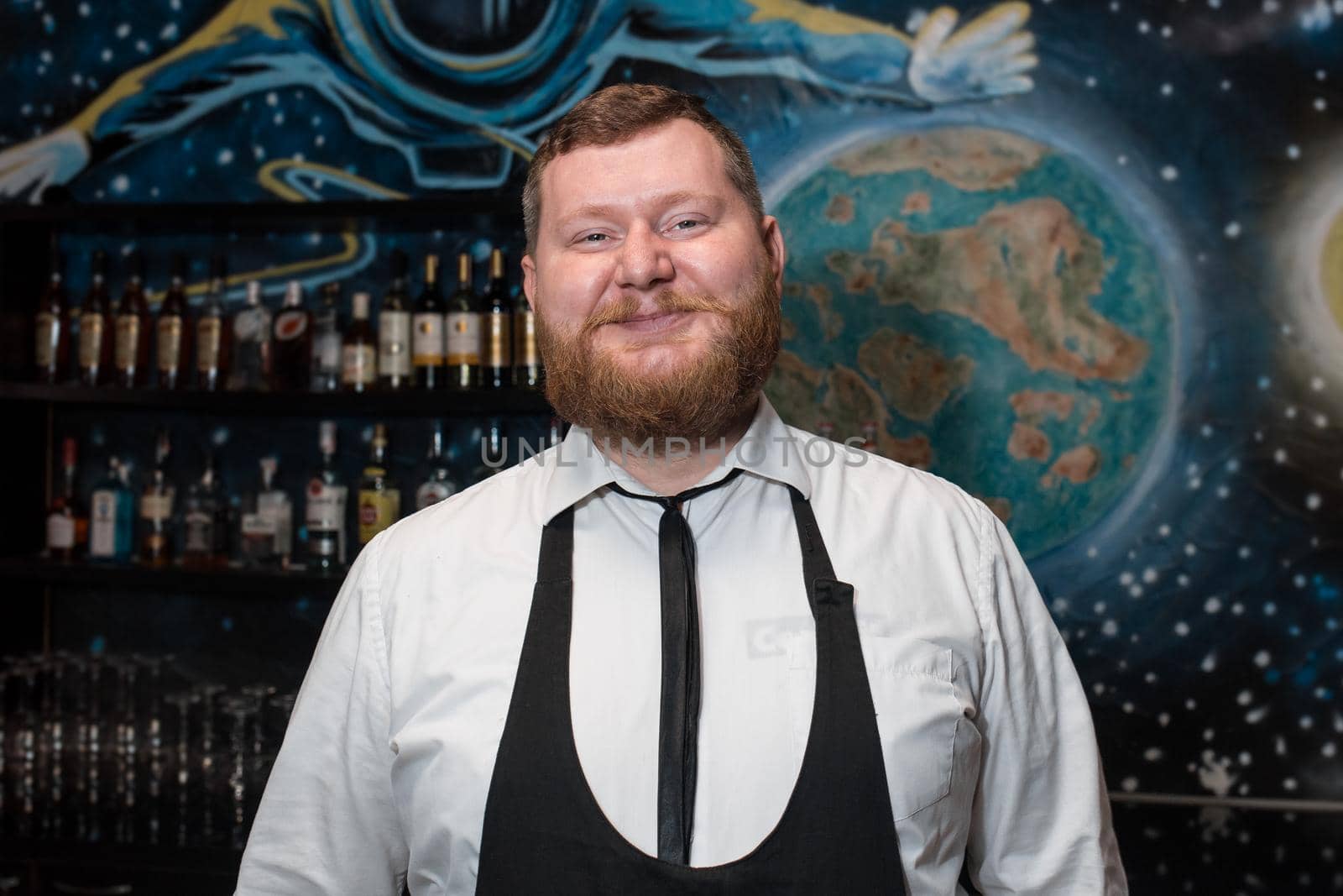 Bearded Adult Funny Positive Smiling Caucasian Looking Professional Bartender Portrait in Nightclub.