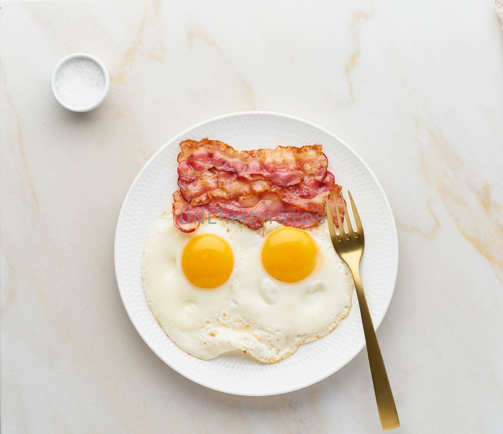 fried eggs with bacon, foodmap ketogenic keto diet, top view, background fork and salt