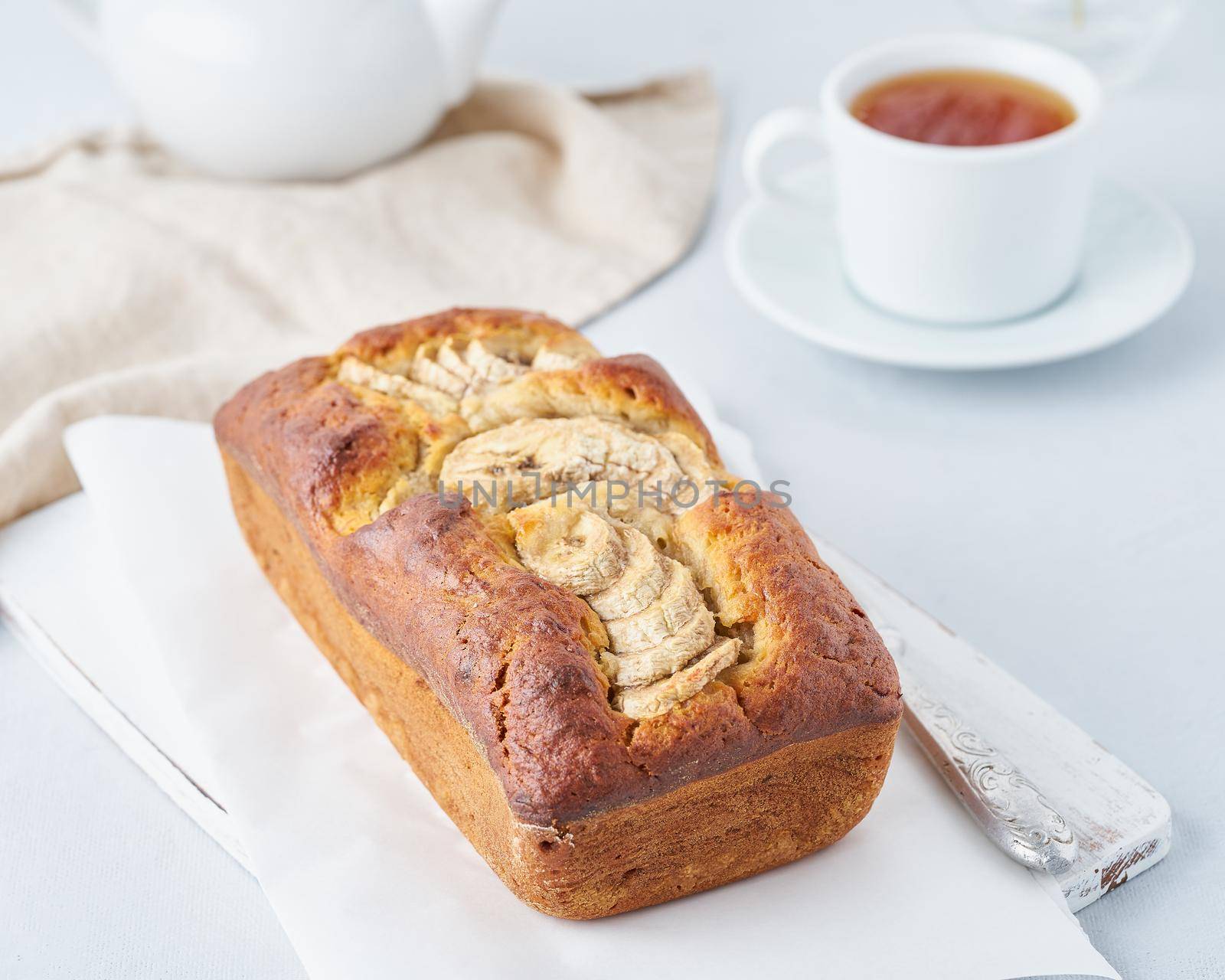 Whole banana bread, cake with banana. The morning Breakfast on a light grey background