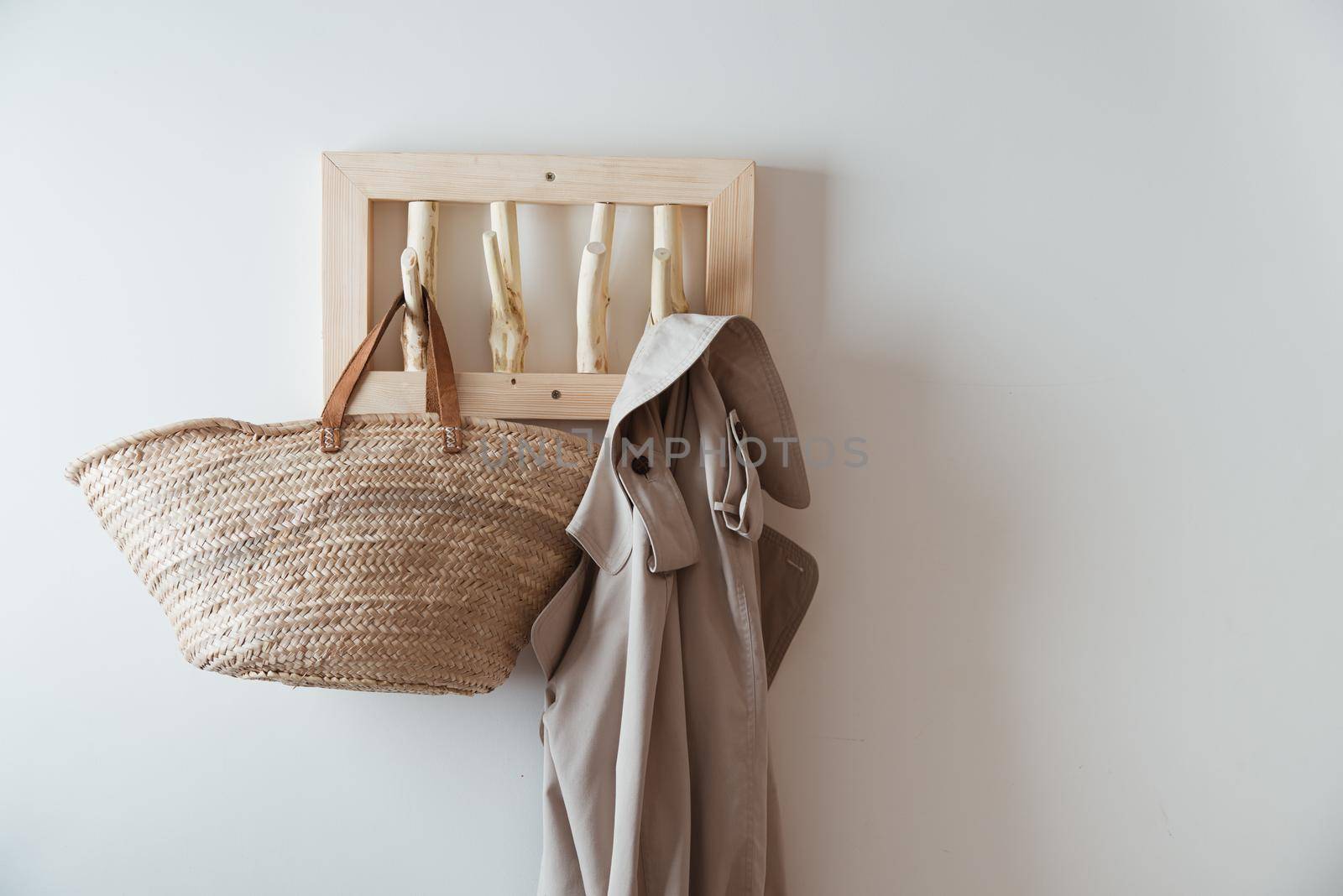 straw bag and trench on handmade wooden hang. Concept of slowlife home. High quality photo