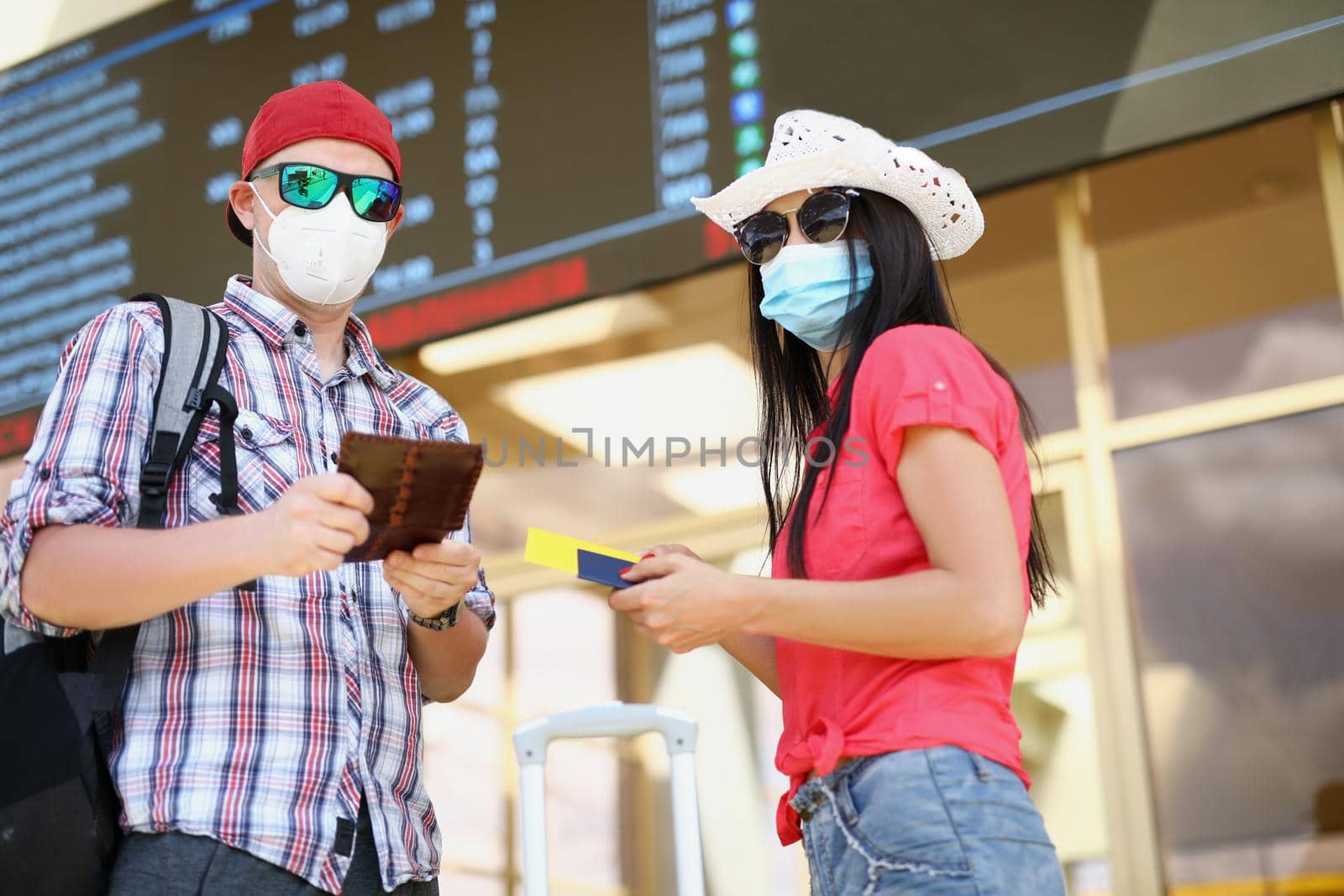 Man and woman in airport, couple waiting for flight holding tickets by kuprevich