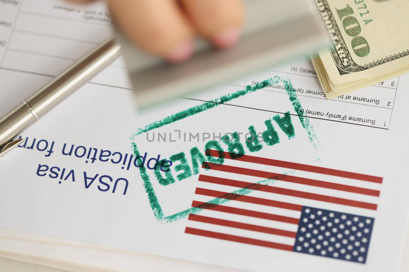 Close-up of green approved stamp on document, visa application form, hand stamping approved on sheet. Permit, authority, resident, allowed to enter concept