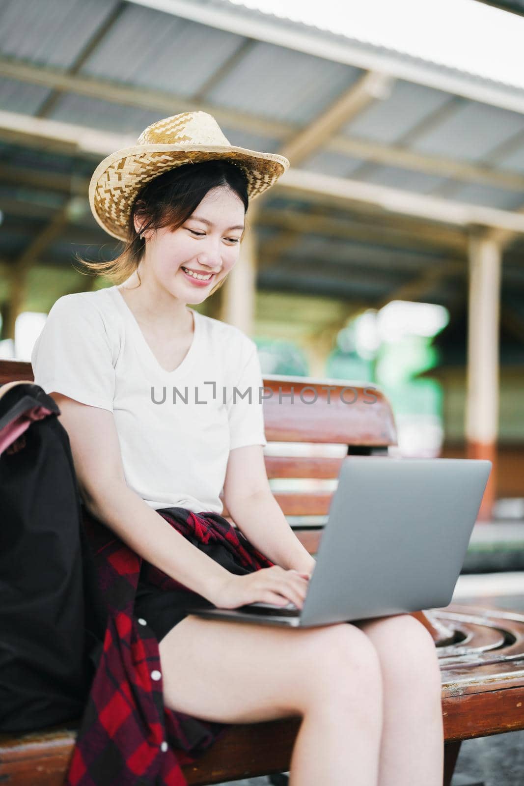 summer, relax, vacation, travel, portrait of beautiful Asian girl using the computer laptop at the train station while waiting for their travel time