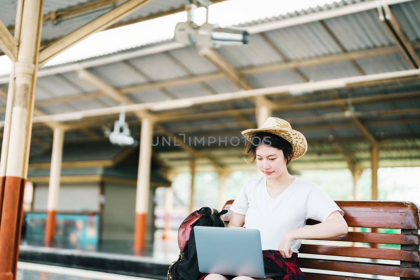 summer, relax, vacation, travel, portrait of beautiful Asian girl using the computer laptop at the train station while waiting for their travel time