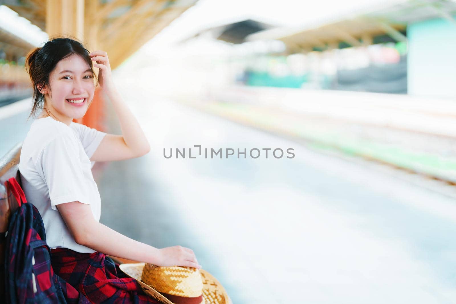 summer, relax, vacation, travel, portrait of cute Asian girl showing smile and showing joy while waiting at the train station for a summer trip