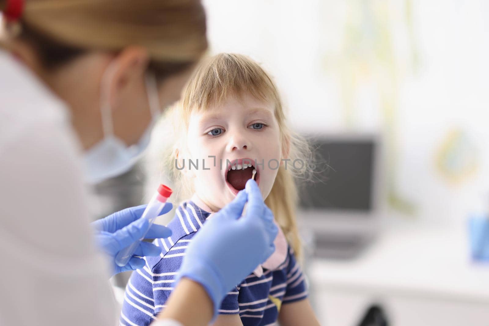 Portrait of laboratory assistant in protective suit takes swab from childs throat, procedure at home, lab test for coronavirus. Quarantine, covid concept