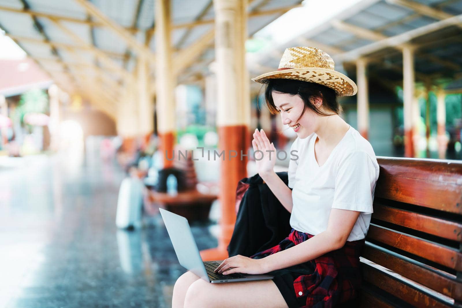 summer, relax, vacation, travel, portrait of beautiful Asian girl using the computer laptop at the train station while waiting for their travel time. by Manastrong