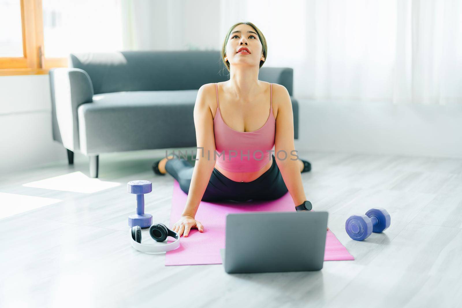 stress relief, muscle relaxation, breathing exercises, exercise, meditation, portrait of Young Asian woman relaxing her body from office work by practicing yoga by watching online tutorials