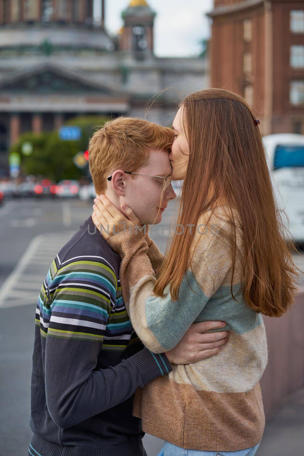 red-haired woman kisses a man on the top of her head, a woman with long dark thick hair in a sweater soothes and comforts a boy by NataBene