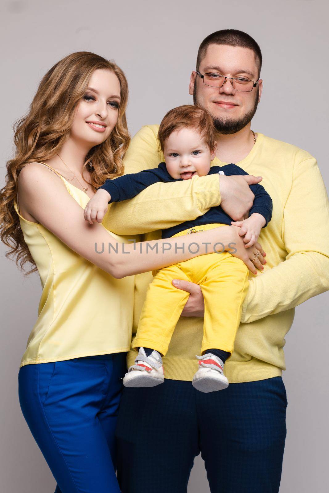 Family in yellow outfit posing on isolated background by StudioLucky