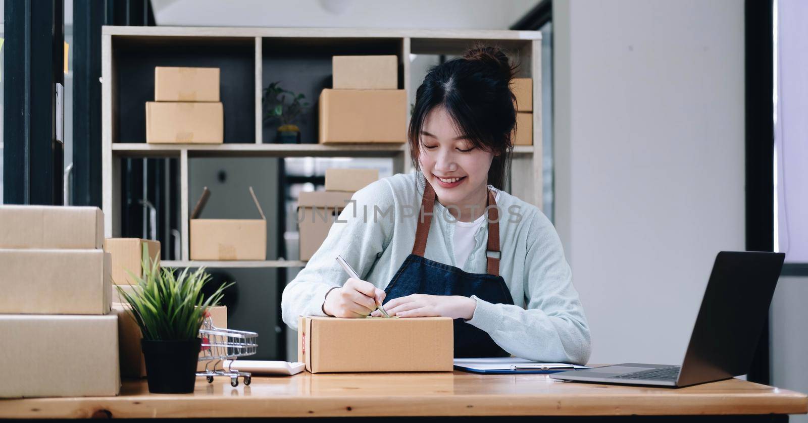 Starting small businesses SME owners female entrepreneurs Write the address on receipt box and check online orders to prepare to pack the boxes, sell to customers, sme business ideas online..