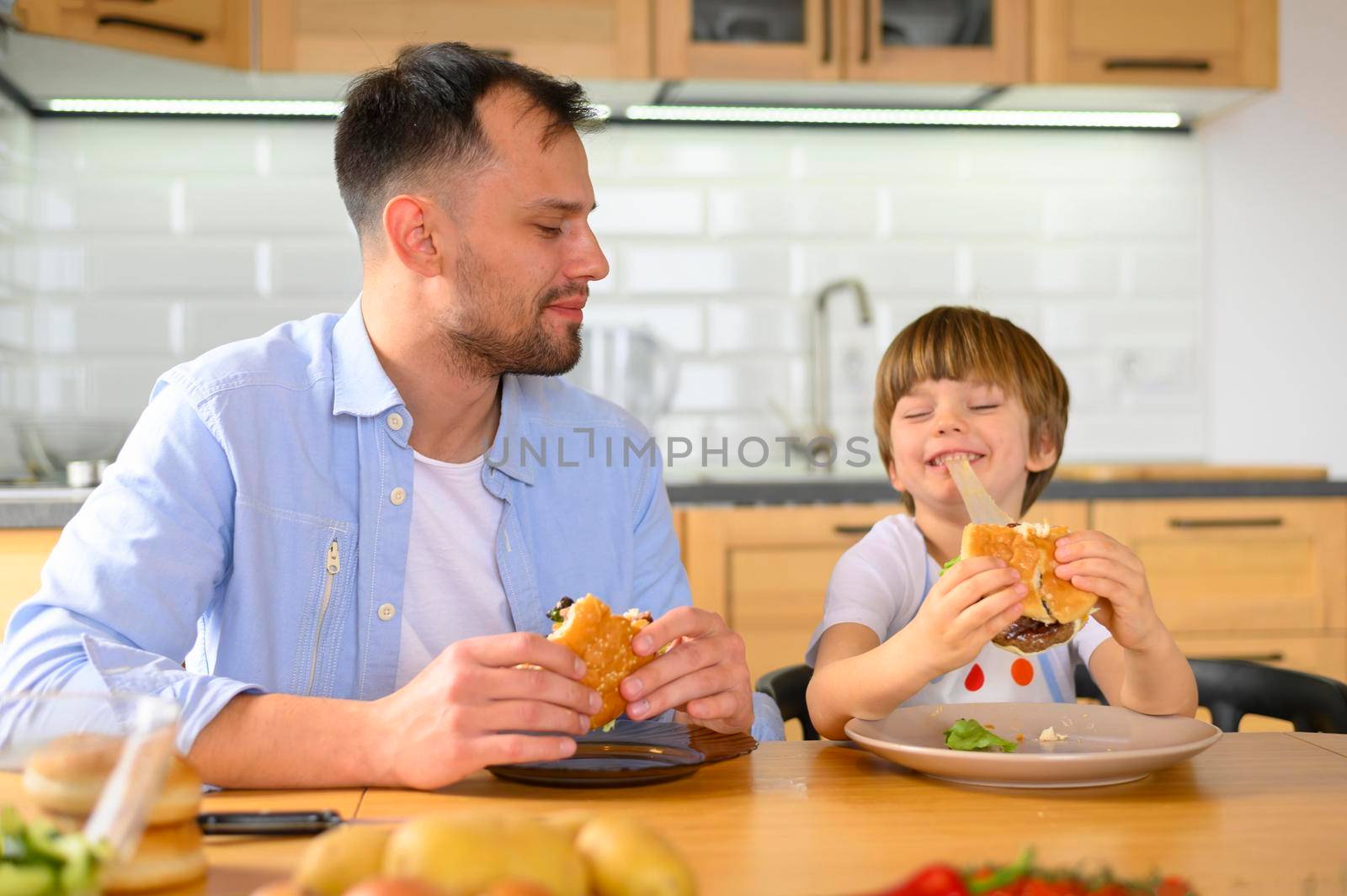 father son eating delicious burgers