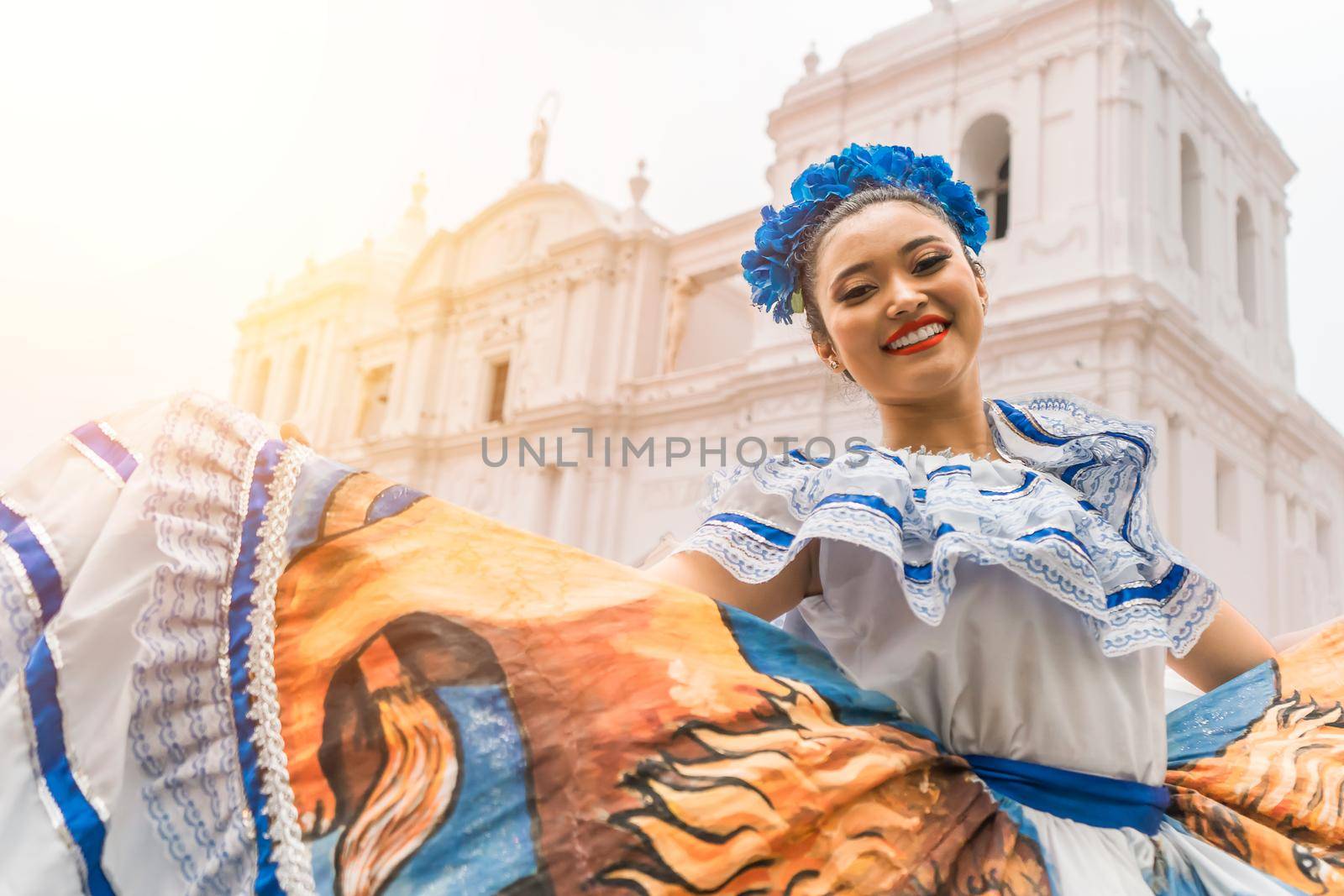 Nicaraguan folklore dancer smiling and looking at the camera outside the cathedral church in the central park of the city of Leon. The woman wears the typical dress of Central America and similar to countries of South America and Mexico.