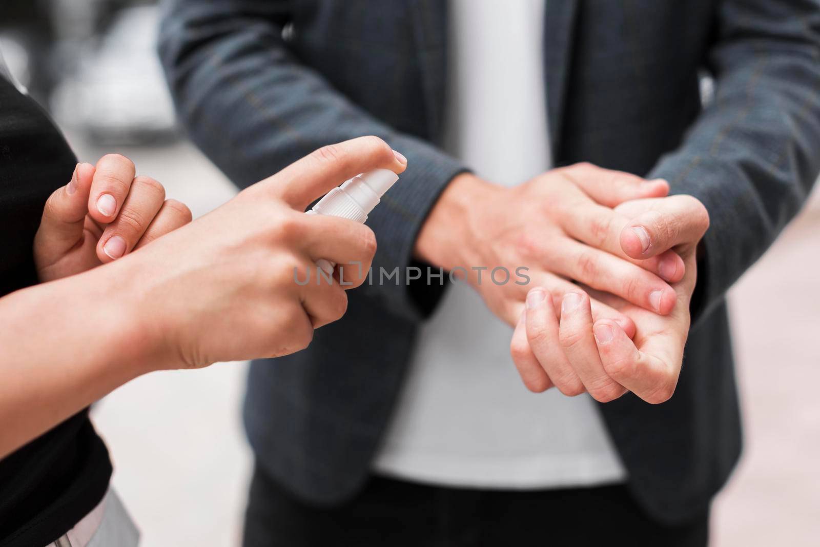 coworkers disinfecting their hands outdoors during pandemic