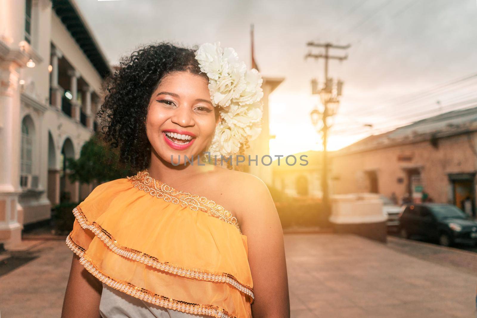 Traditional mestizo dancer from Nicaragua with curly hair smiling looking at the camera at sunset wearing the typical dress of Central America, of Mexico, El Salvador, Guatemala and Honduras