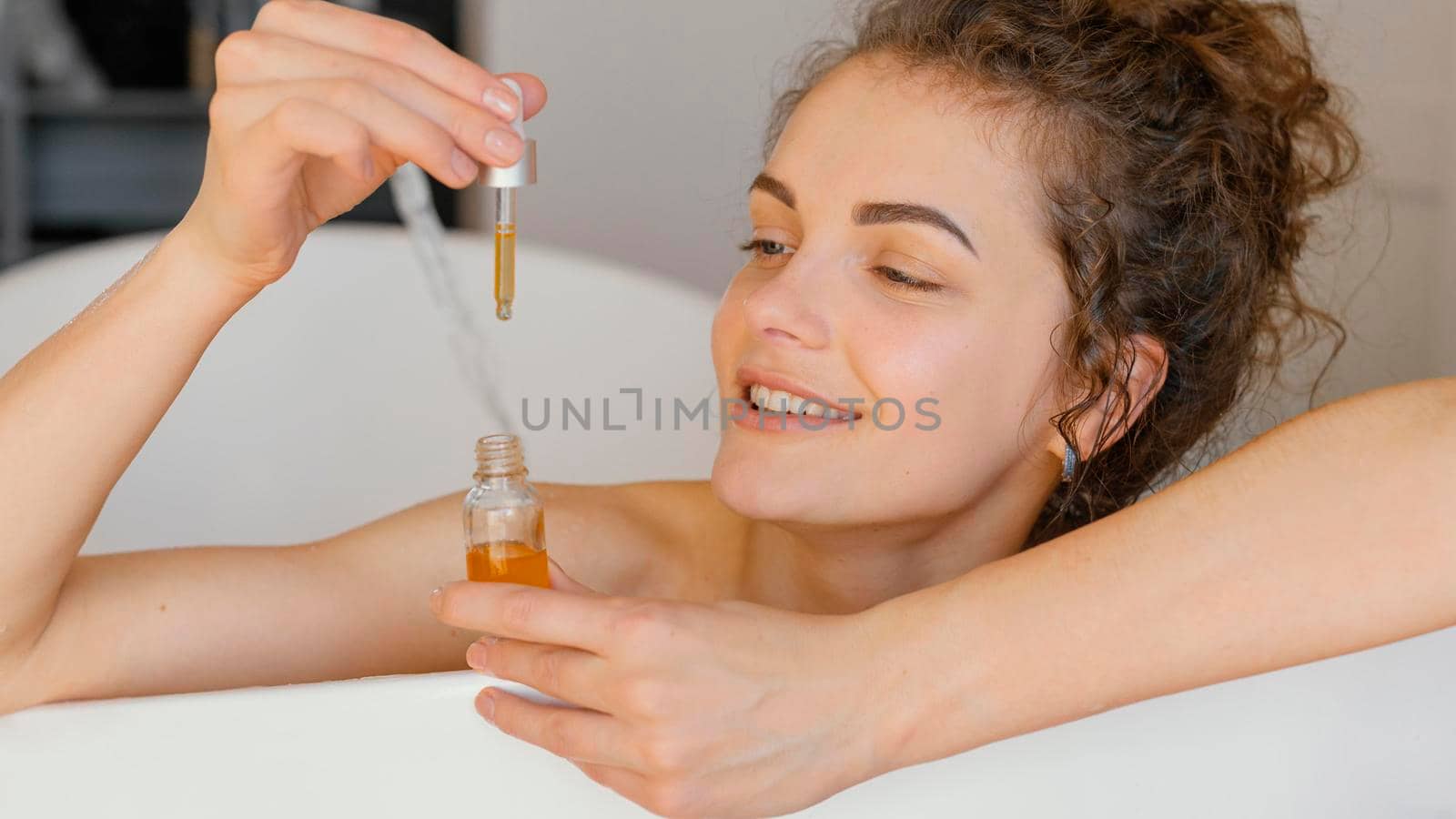 woman relaxing bathtub with serum